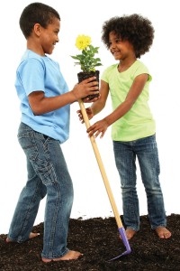 Adorable Black Brother and Sister Planting Flowers Together